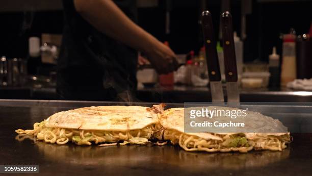 okonomiyaki  is a japanese savory pancake containing a variety of ingredients. toppings and batters tend to vary according to region of japan. - okonomiyaki stock pictures, royalty-free photos & images