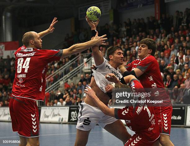 Thomas Lammers of Ahlen-Hamm , Andreas Simon and Rico Goede challenge Marcus Ahlm of Kiel during the Toyota Handball Bundesliga match between HSG...