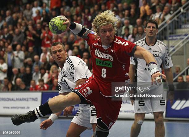 Bjoern Wiegers of Ahlen-Hamm scores a goal against Christian Zeitz of Kiel and Marcus Ahlm of Kiel during the Toyota Handball Bundesliga match...