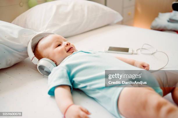 baby genieten van het luisteren naar muziek - bedroom radio stockfoto's en -beelden