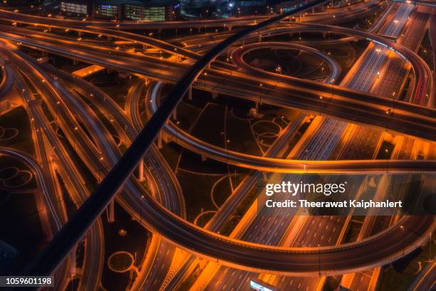 aerial view of a busy road intersection in dubai at night - dubai road stock pictures, royalty-free photos & images