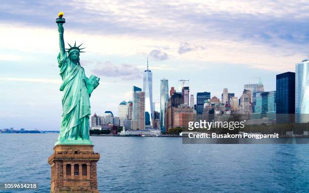 the statue of liberty with world trade center background, landmarks of new york city - new york stock pictures, royalty-free photos & images