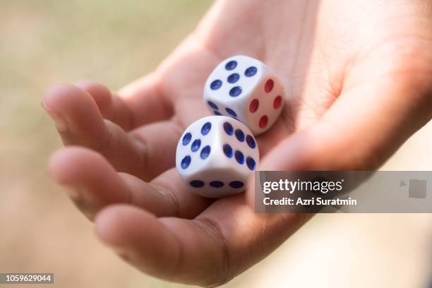 male hand rolling white dices - dice pair stock-fotos und bilder