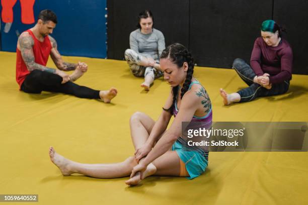 fitness-instruktor führt cooldown-sitzung - mixed martial arts stock-fotos und bilder