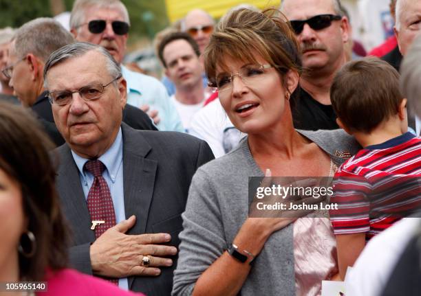 Maricopa County Sheriff Joe Arpaio and Politician and conservative activist Sarah Palin, with her son Trig Palin, listen to the National Anthem...