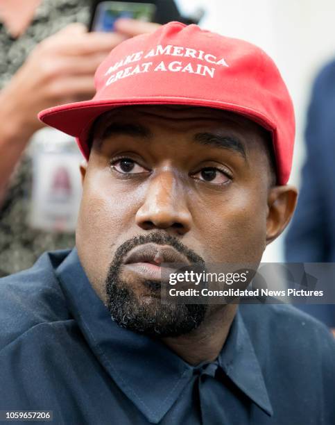 Close-up of American rapper and producer Kanye West in the White House's Oval Office, Washington DC, October 11, 2018. He wears a red baseball cap...