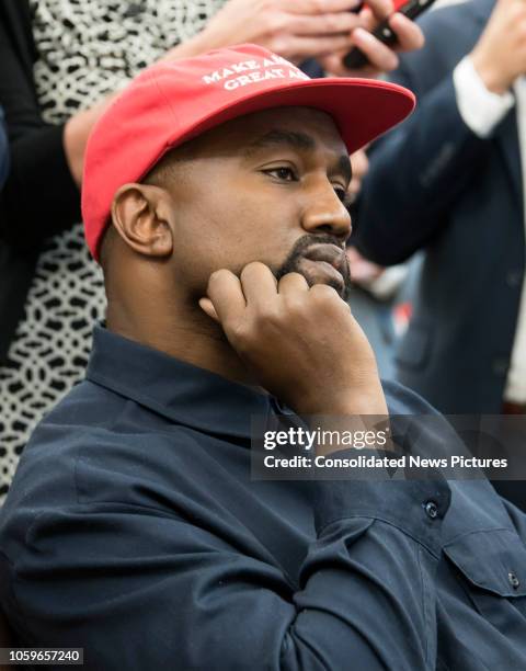 Close-up of American rapper and producer Kanye West in the White House's Oval Office, Washington DC, October 11, 2018. He wears a red baseball cap...