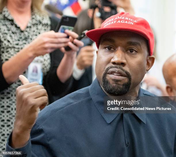 Close-up of American rapper and producer Kanye West in the White House's Oval Office, Washington DC, October 11, 2018. He wears a red baseball cap...