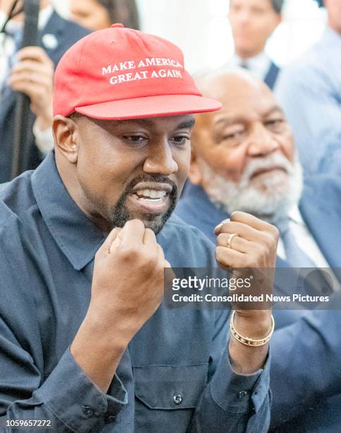 View of American rapper and producer Kanye West, with his fists raised, in the White House's Oval Office, Washington DC, October 11, 2018. He wears a...