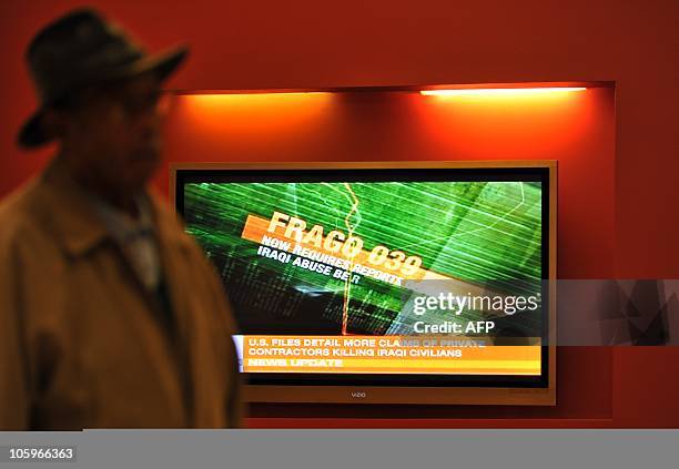 Woman walks past a television set displaying the Al-Jazeera news channel telecast on secret US documents obtained by WikiLeaks, in Silver Spring,...