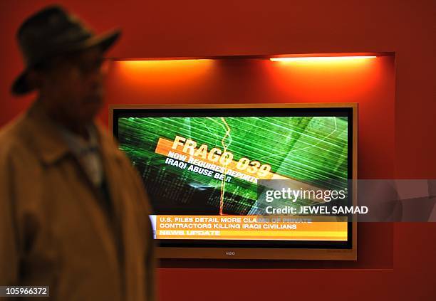 Man walks past a television set displaying the Al-Jazeera news channel telecast on secret US documents obtained by WikiLeaks, in Silver Spring,...