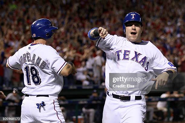 Mitch Moreland and Josh Hamilton of the Texas Rangers celebrate after they scored on a 2-run double by Vladimir Guerrero ini the bottom of the fifth...