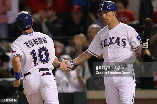 Michael Young of the Texas Rangers is congratulated by David Murphy after scoring on a sacrifice fly by Ian Kinsler in the seventh inning of Game Six...