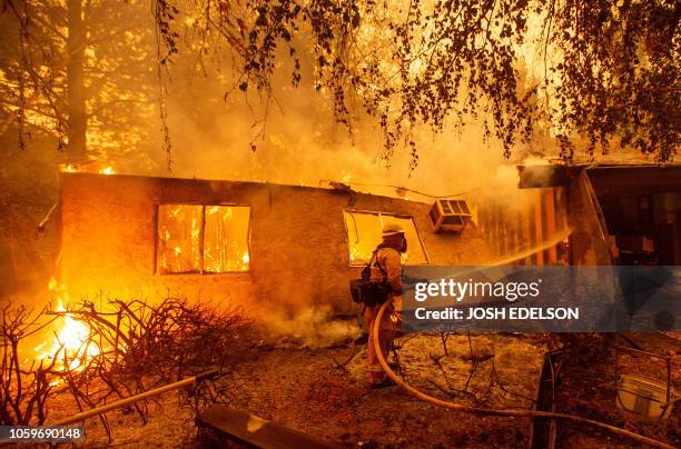 Firefighters battle flames at a burning apartment complex in Paradise, north of Sacramento, California on November 09, 2018. A rapidly spreading,...