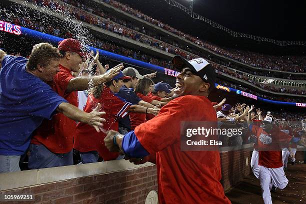 Nelson Cruz of the Texas Rangers sprays ginger ale on the fans as the Rangers celebrate thei r6-1 win against the New York Yankees in Game Six of the...