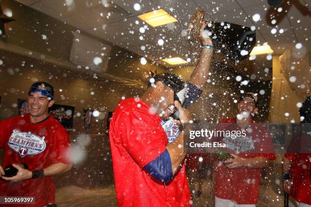 Nelson Cruz of the Texas Rangers holds the Warren C. Giles Trophy in the lockerroom with teammates after defeating the New York Yankees 6-1 in Game...