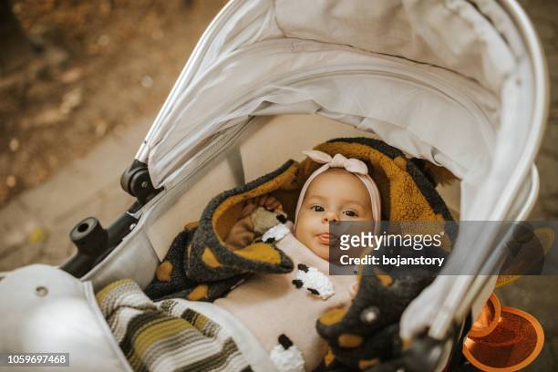 kleines mädchen, das in einem kinderwagen liegt - baby stroller stock-fotos und bilder