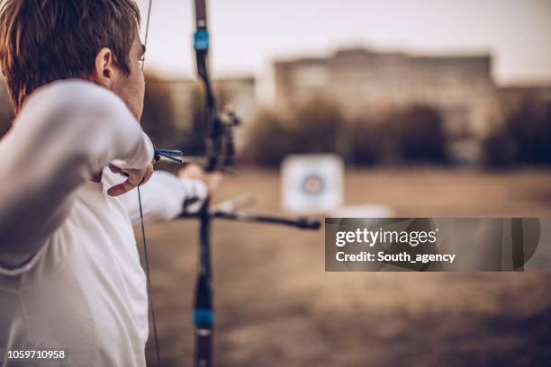 mann, mit dem ziel ziel - bow arrow stock-fotos und bilder