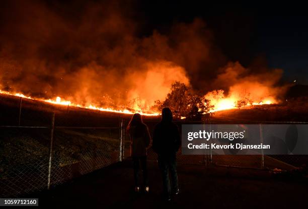 Residents take a look at the Woolsey Fire burning brush and trees on November 9, 2018 in Agoura Hills, California. About 75,000 homes have been...