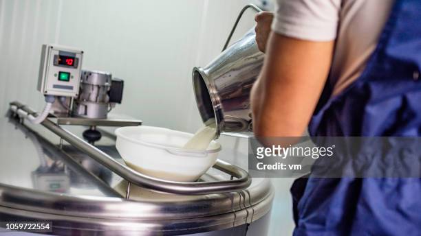 cheese maker pouring milk into a stainless steel heating element - yogurt container stock pictures, royalty-free photos & images