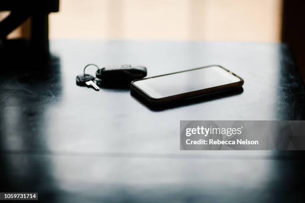 mobile phone and car keys on table - car keys table stock-fotos und bilder