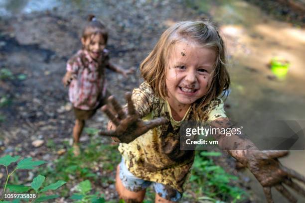 smiling little muddy girl - mood stream stock pictures, royalty-free photos & images