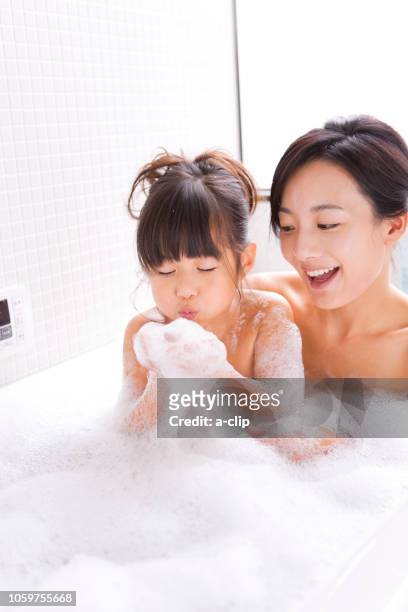 泡風呂の泡で遊ぶ母娘 - お風呂　親子 ストックフォトと画像