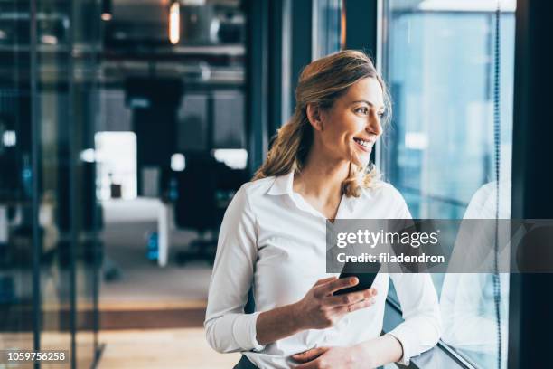 texting - business woman looking through window stock pictures, royalty-free photos & images