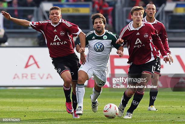 Mike Frantz and Jens Hegeler of Nuernberg fight for the ball with Diego of Wolfsburg while Julian Schieber of Nuernberg watches them during the...