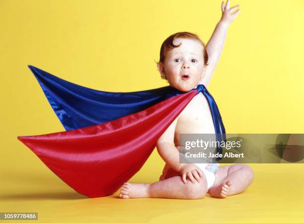 superhero baby - baby being held stockfoto's en -beelden