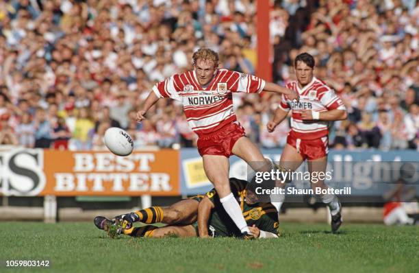 Wigan captain Shaun Edwards skips the tackle of Kangaroos captain Mal Meninga during the tour match between Wigan and Australia at Central Park on...