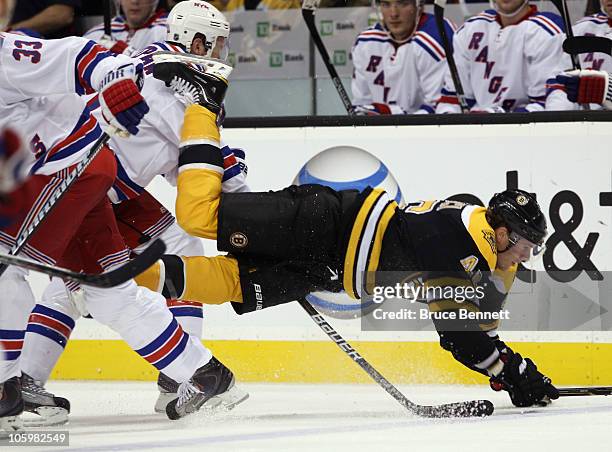 Michal Rozsival of the New York Rangers trips up David Krejci of the Boston Bruins at the TD Garden on October 23, 2010 in Boston, Massachusetts.