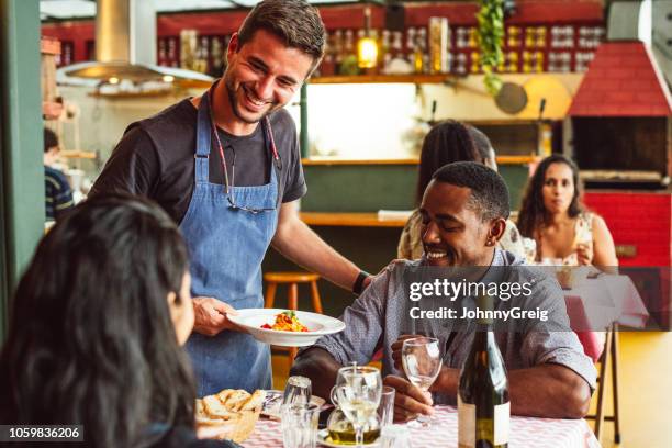 allegro chef maschio che serve coppia in ristorante e sorridente - coppie cibo food bistrot foto e immagini stock