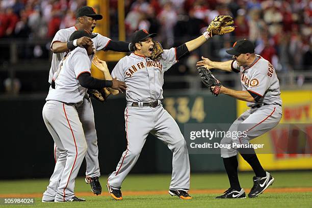 Freddy Sanchez, Juan Uribe, Edgar Renteria and Nate Schierholtz of the San Francisco Giants celebrate defeating the Philadelphia Phillies 3-2 and...