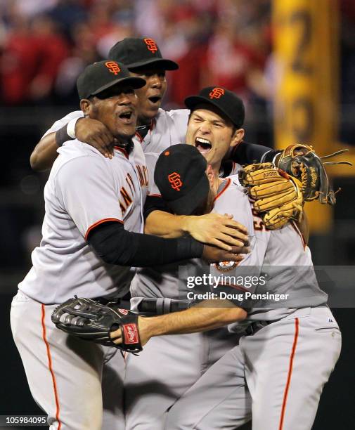 Freddy Sanchez, Juan Uribe, Edgar Renteria and Nate Schierholtz of the San Francisco Giants celebrate defeating the Philadelphia Phillies 3-2 and...