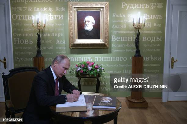 Russian President Vladimir Putin makes an entry in the Honoured Visitor Book as he visit the Ivan Turgenev Museum on Ostozhenka Street in Moscow on...
