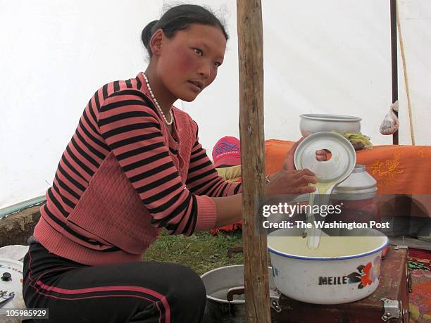 Marjo Herji churns butter out of yak milk in her traditional tent in the Xiala grasslands, Qinghai Province, China, in the southrn mountain grazing...