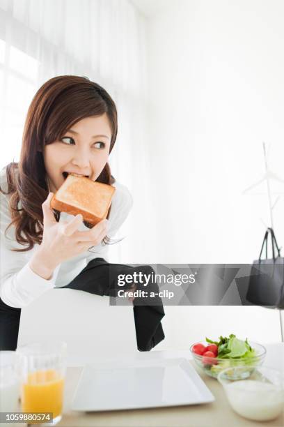 a woman before work sheiru bread - businessperson breakfast stock-fotos und bilder