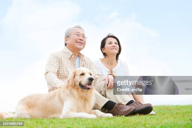 mature couple and dog looking up at the sky - prairie dog 個照片及圖片檔