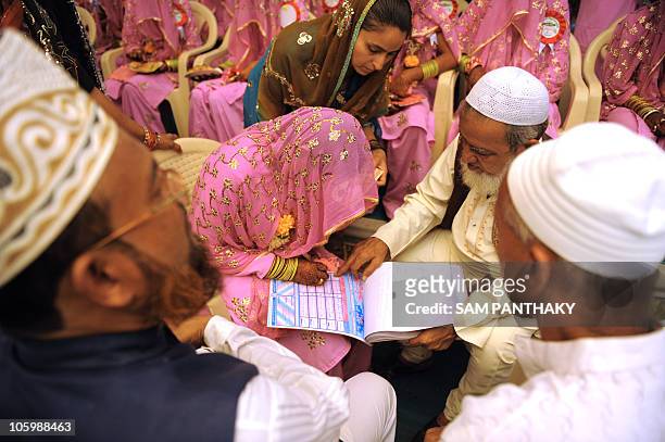 An Indian Muslim bride signs a Marriage Certificate in the presence of religious leaders and a relative during the "Nikah Kabool Hai" or "Do You...