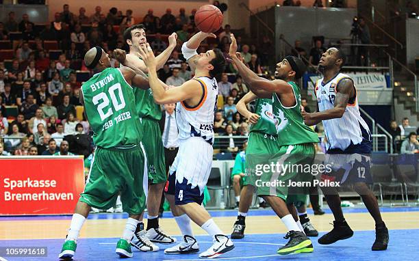 Jan Lipke of Bremerhaven and John Redder Bynum and Philip Zwiener and Dru Joyce of Trier battle for the ball during the Basketball Bundesliga match...