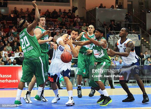 Jan Lipke of Bremerhaven and John Redder Bynum and Philip Zwiener and Dru Joyce of Trier battle for the ball during the Basketball Bundesliga match...