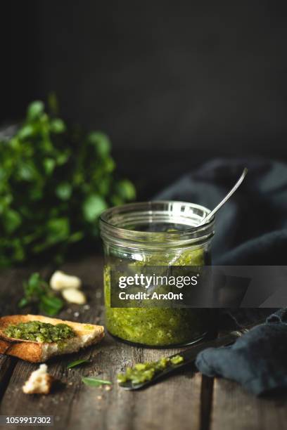 green pesto sauce in a jar - pesto stock-fotos und bilder