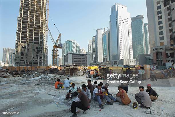 Construction workers from Bangladesh take a break near new highrise office buildings and hotels still under construction in the new City Center and...