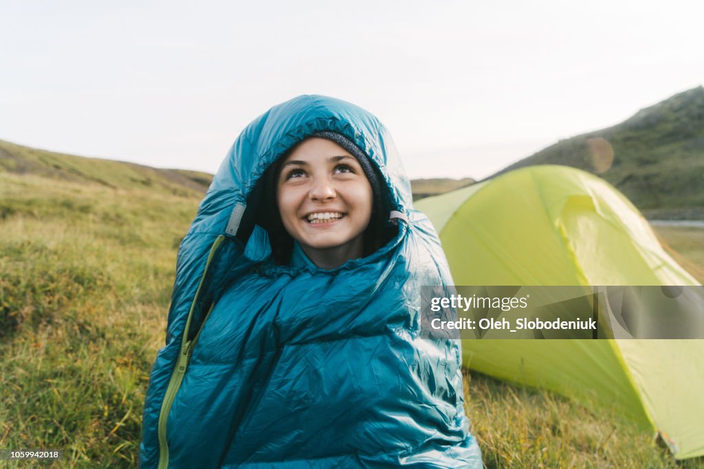 Woman in sleeping bag near the tent in Iceland