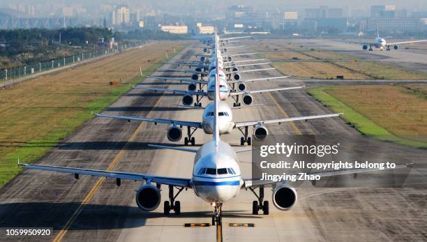 so many airplanes are in line on the runway waiting for take off - aerial view construction workers photos et images de collection