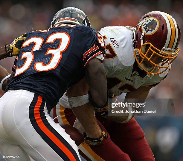 Chris Cooley of the Washington Redskins fumbles the ball as he is hit by Charles Tillman of the Chicago Bears at Soldier Field on October 24, 2010 in...