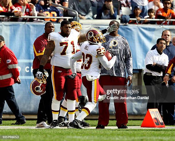 Trent Williams of the Washington Redskins points to the end zone as teammate DeAngelo Hall takes an interception in for a touchdown against the...