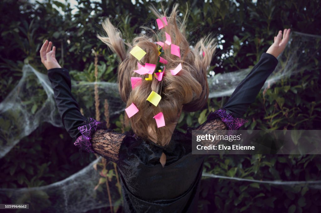 Sticky paper notes in a girl's long brown hair, blowing in a gust of wind