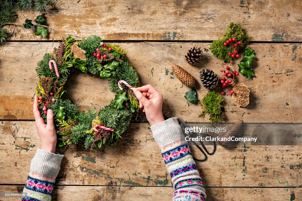 Overhead view of Christmas wreaths being made.